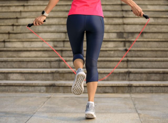 Fitness woman jumping rope in city