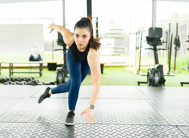 Active young woman doing a cardio workout routine and working out with lateral bound exercises