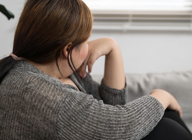 Sad Overweight plus size woman thinking about problems on sofa upset girl feeling lonely and sad from bad relationship or Depressed woman disorder mental health