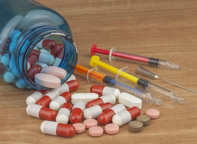 Doping in sport. Abuse of anabolic steroids for sports. Anabolic steroids spilled on a wooden table. Fraud in sports. Pharmaceutical industry. Detailed view of the medication. Place for your text.