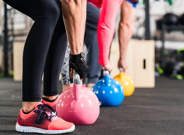 Group having functional fitness training with kettlebell in sport gym