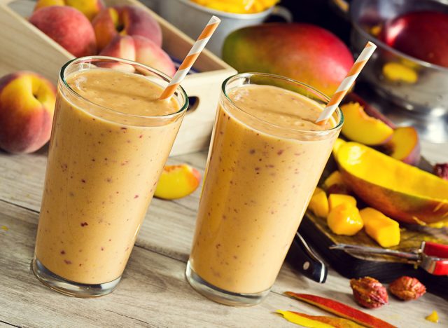 Peach Mango Smoothies or Milkshakes in Glasses with Ingredients on Wooden Table