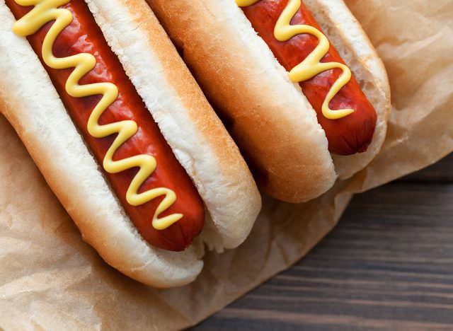 Barbecue Grilled Hot Dog with Yellow Mustard and ketchup on wooden table