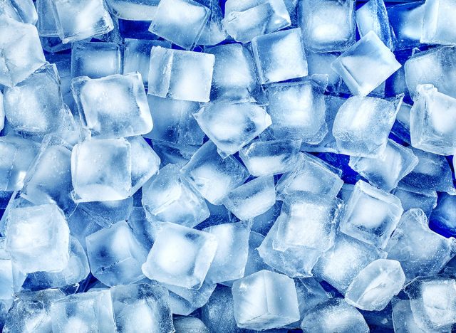 Ice cubes for cocktails close-up on a blue background.