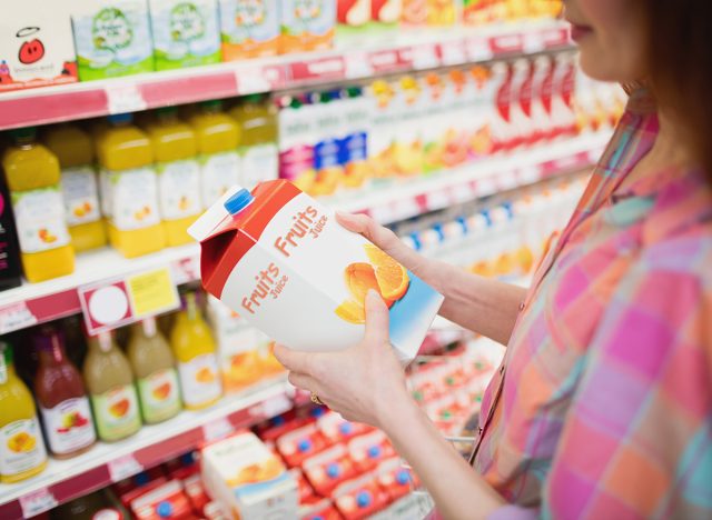 Close up view of woman buying fruits juice at supermarket