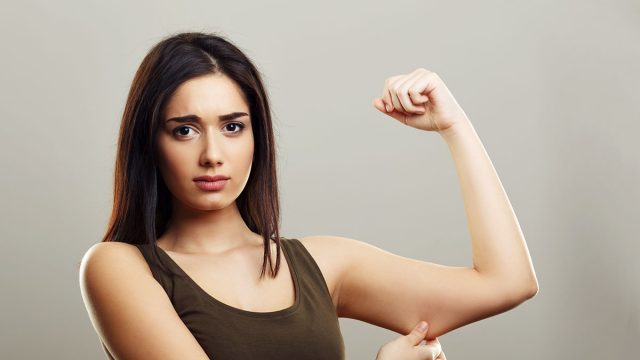 Young woman pinching arm fat flabby skin