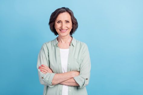 Photo portrait senior woman smiling happy folded hands in casual shirt isolated pastel blue color background.