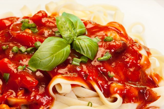 Pasta fettuccine with tomato sauce and basil on a plate