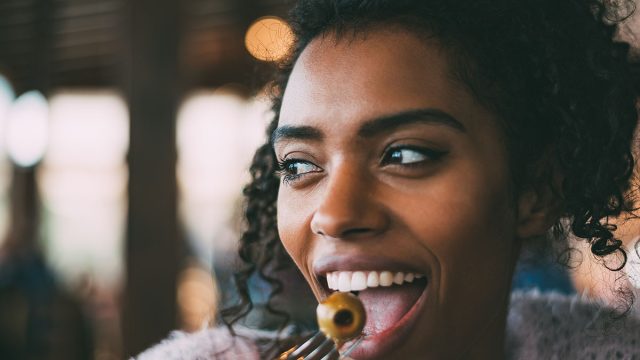 Black woman eating olives