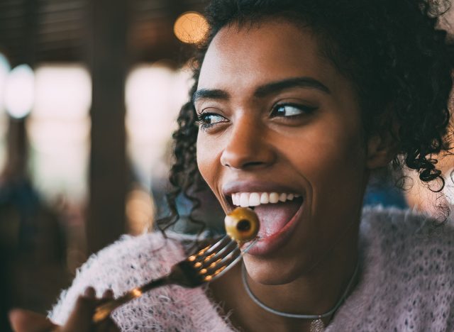 Black woman eating olives