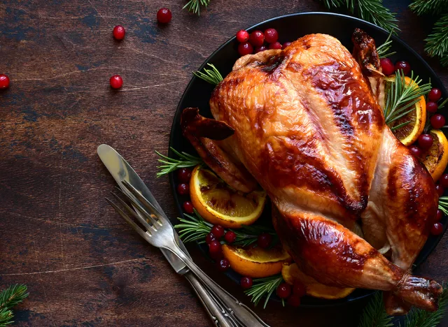 Roasted chicken with oranges ,rosemary and cranberries on a christmas table. Top view with copy space.