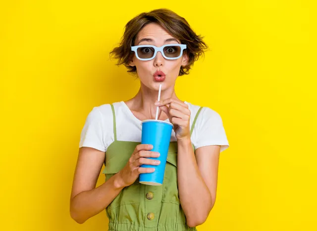 Portrait photo of impressed shocked woman bob brown hair wear 3d glasses specs poued lips drink soda nice film isolated on yellow color background