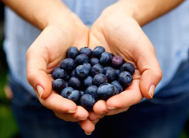 Close up portrait of handful of fresh blueberries