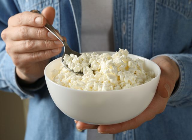 Woman hold bowl with cottage cheese, close up