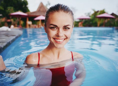 cheerful smiling woman in swimsuit in the pool island nature