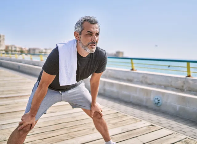 Middle age hispanic man wearing sportswear resting at seaside