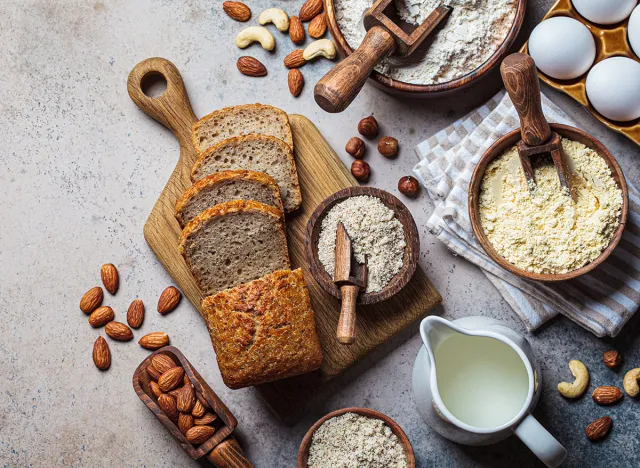 Keto bread cooking. Different types of nut flour - almond, hazelnut, cashew and baking ingredients, dark background, top view. Gluten free concept.