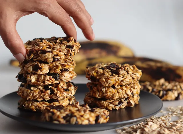 Healthy evening snacks made of rolled oats, pureed ripe plantains and raisins. Shot on white background with ripe plantain and oats around