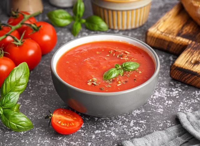 Bowl of delicious tomato soup on grunge background