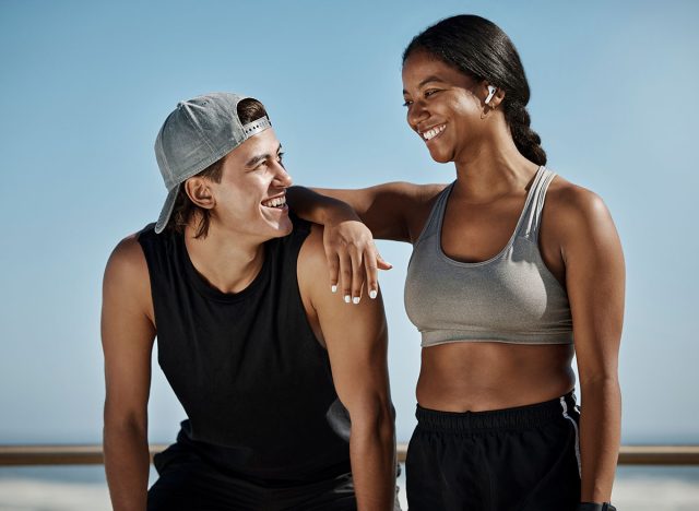 Fitness, couple and man and black woman with smile go exercise or running. Strong and happy couple workout and run together. Wellness, sports and health, runner and personal trainer workout in park