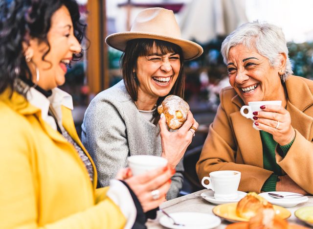 Group of senior women at bar cafeteria enjoying breakfast drinking coffee and eating croissant - Life style concept - Mature female having fun at bistrò cafe and sharing time together