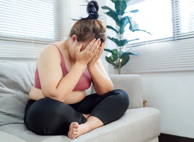 Obese Woman with fat upset bored of dieting Weight loss fail  Fat diet and scale sad asian woman on weight scale at home weight control.