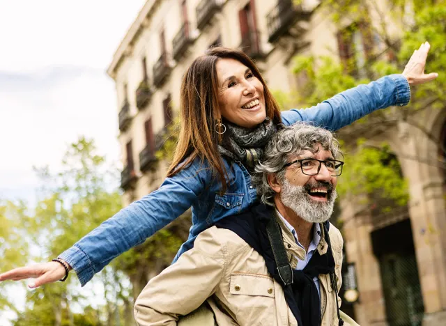 Happy senior couple having fun together on vacation at city street. Two mature people enjoying time together during summer holidays.