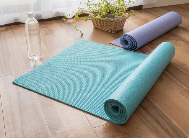 A rolled up yoga mat and water. Do yoga in the room.