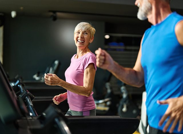 Portrait of a senior woman exercising in a gym, mature couple running using threadmill machine equipment, healthy lifestyle and cardio exercise at fitness club concepts, vitality and active senior