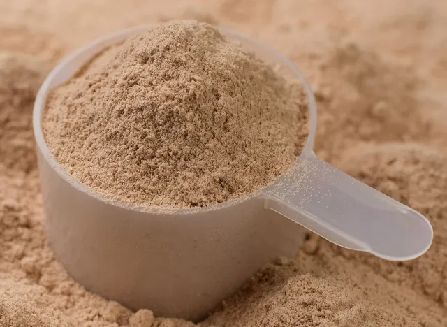 Chocolate colour protein, whey powder sprinkle in cup. Bodybuilding, fitness and gym lifestyle