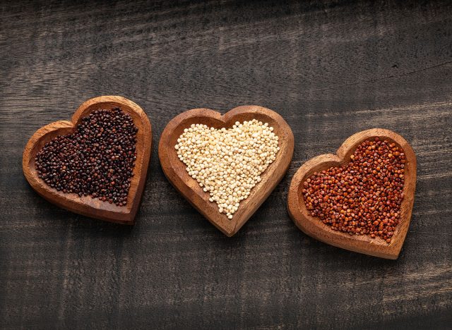 White, red and black quinoa seeds in three heart-shaped bowls - Chenopodium quinoa