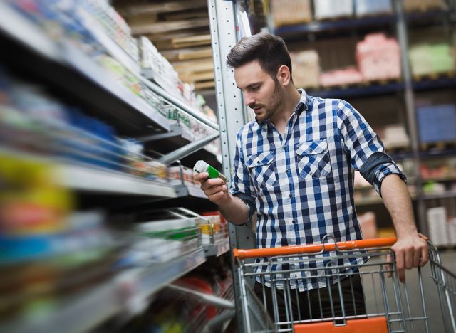 Man shopping in supermarket while pushing shopping cart