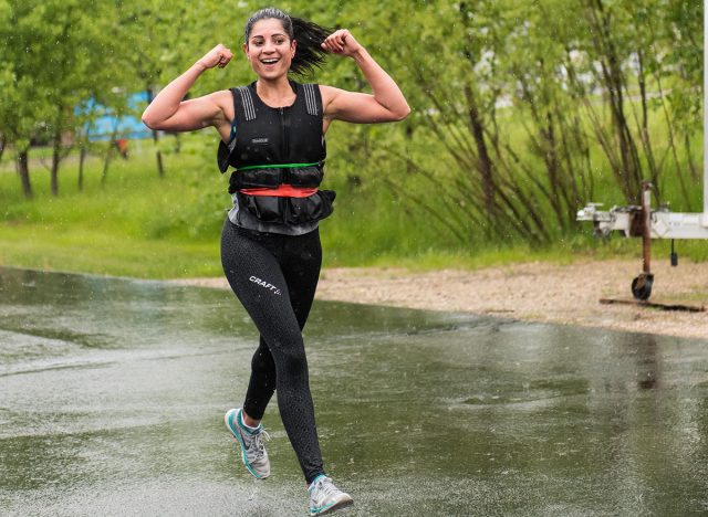 Buffalo, Minnesota, USA - May 20, 2017 Murph Challenge 2017, Happy athletic girl coming back from 1 mile run and flexing her biceps