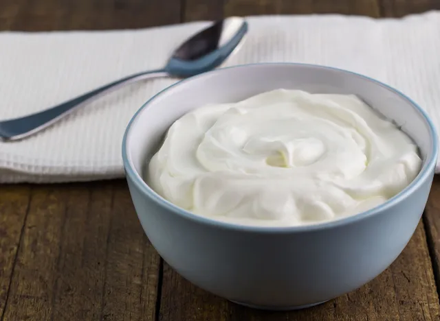 Natural creamy Greek yoghurt on wooden table background