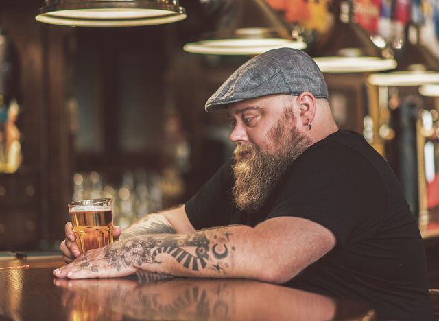 Pensive guy drinking light ale in pub