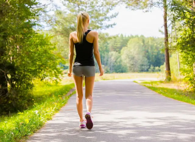 Young woman walks alone on a road outdoor