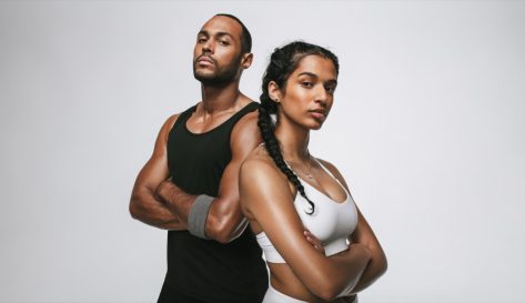 Close up of male and female athlete standing with arms crossed.