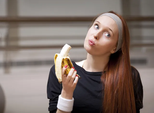 Woman eating banana at the gym for energy