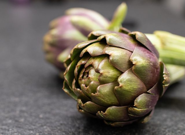 Artichoke flower fresh on dark background. Organic healty artichoke