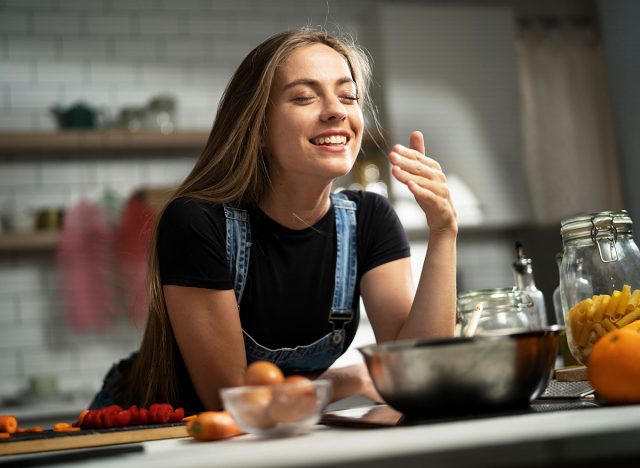 Young woman in kitchen. Beautiful woman making delicious food.