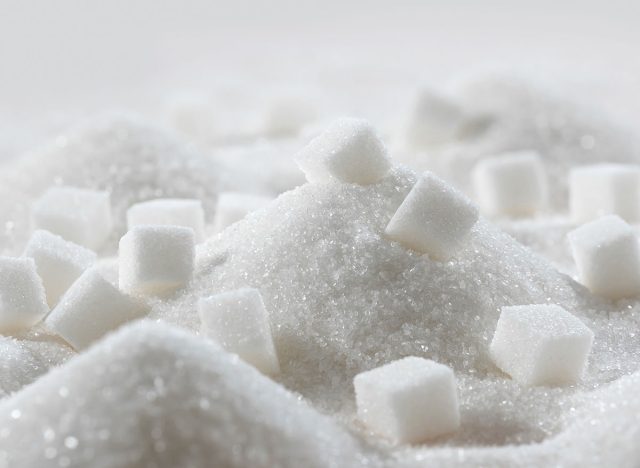 White granulated sugar and refined sugar cubes close-up in the kitchen