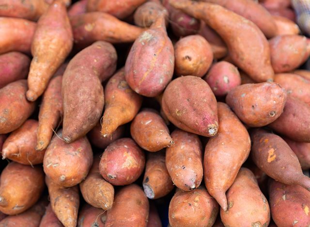 Raw sweet potato tubers for sale on market counter. Vegetarian food concept