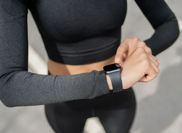 Uses a fitness watch bracelet. woman sports lifestyle fitness in the city cardio endurance training.