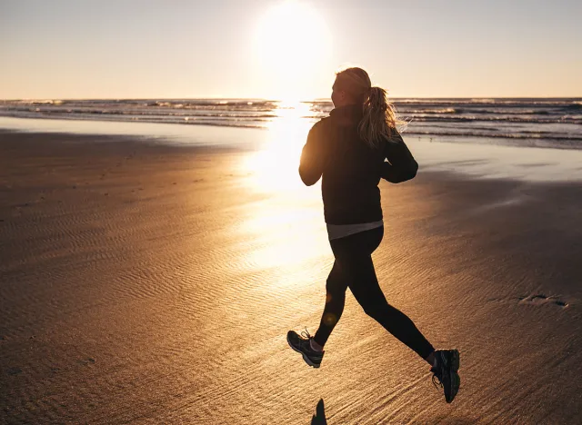 Female Runner on the Beach at Sunset silhouette in air