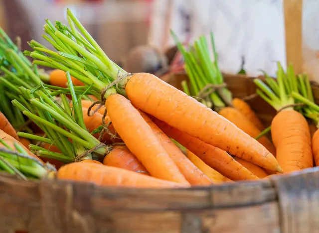 Bunch of carrots in basket. Fresh carrots bunch. Fresh organic carrots.