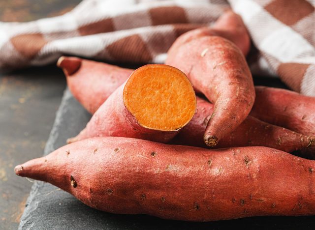 fresh sweet potatoes on a dark rustic background.