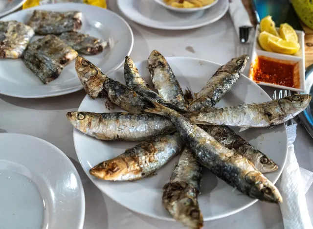 Fried sardines on Moroccan street restaurant plate with lemon wedges, sauce, and sides. Tasteless and expensive food for tourists, popular local cuisine on Essaouira fish market