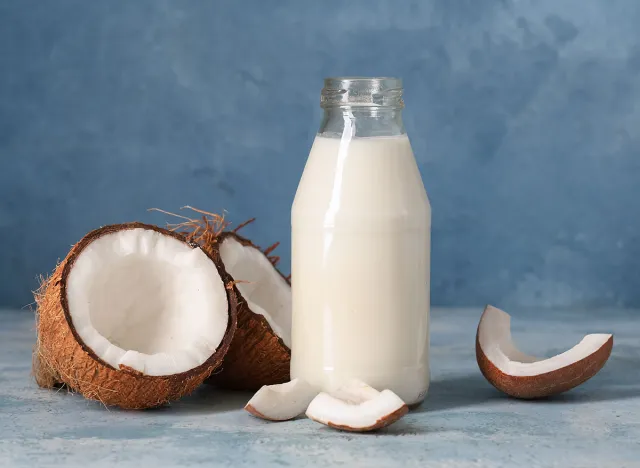 Bottle of tasty fresh coconut milk on blue grunge background