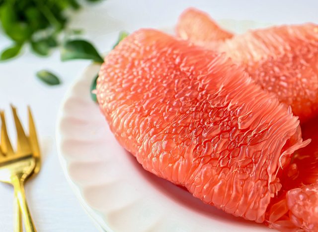 Grapefruit Ruby of Siam,Siam ruby grapefruit, tabtimsiam pomelo, red pomelo, in white plate on white table background, , close up food