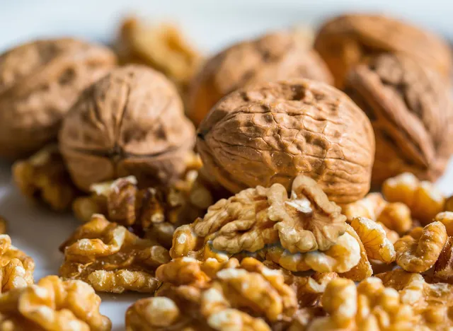 Pile of ripe walnuts background, Walnuts isolated on white background with clipping path, collection. Walnut nuts horizontal composition. Side view.